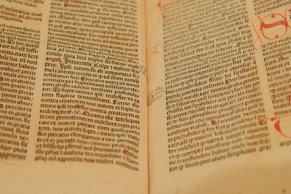 Detailed image of an ancient manuscript featuring Latin text on yellowed pages.